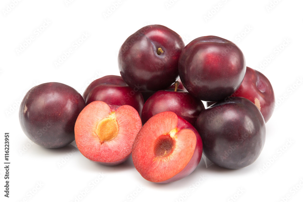 Haufen roter runde Pflaumen mit halbierten Früchten auf weißem Hintergrund