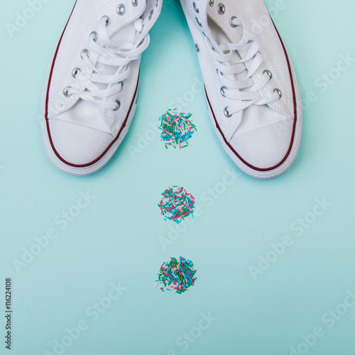 flat lay fashion set by white gumshoes on mint colored background