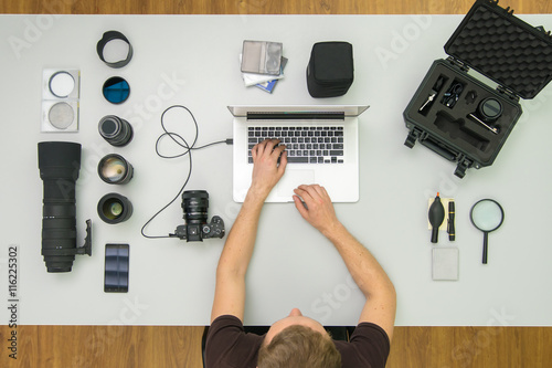 The man work with laptop and tool on the desktop. Wide angle