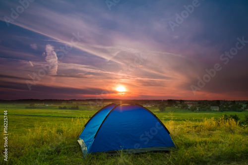 The camping tent stand on the background of picturesque sky. Wide angle