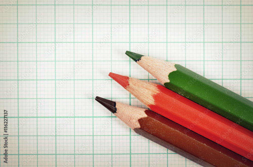 Fototapeta premium Colored pencils with graph plotting paper for background