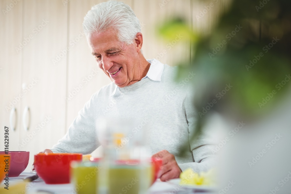 Senior man smiling during the lunch Senior man smiling during the lunch