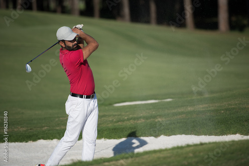 golfer hitting a sand bunker shot