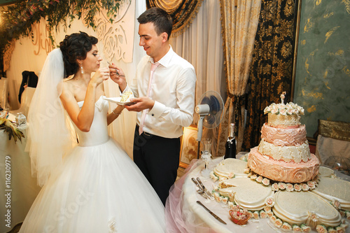 The brides eatting a wedding cake photo