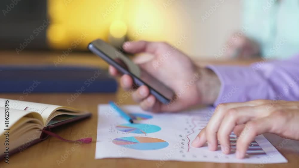 At the business meeting colleagues discussing charts using gadgets At the business meeting colleagues discussing charts using gadgets