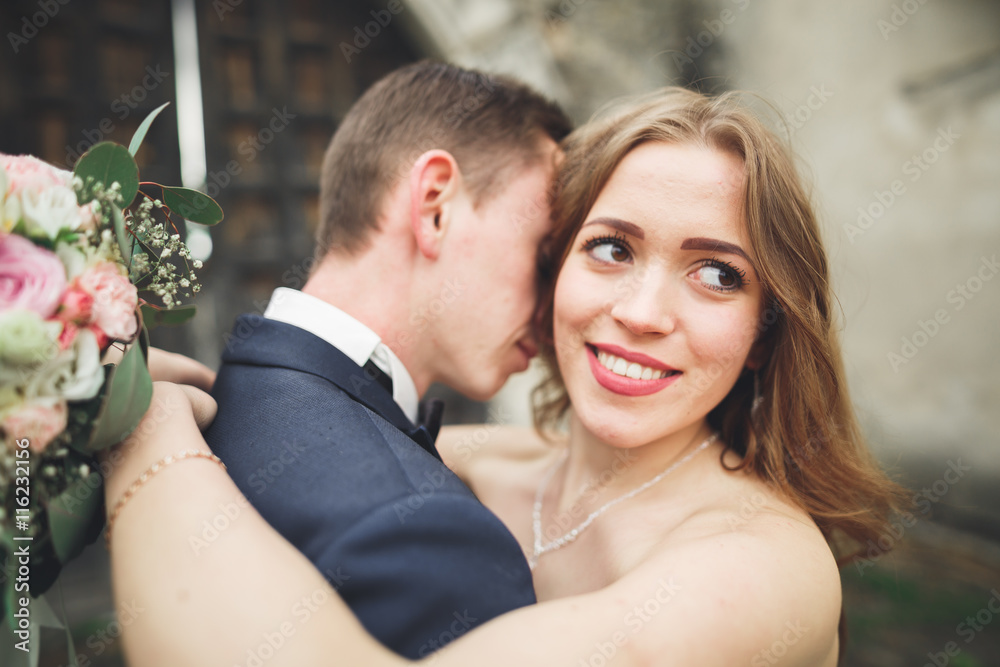 Beautiful romantic wedding couple of newlyweds hugging near old castle Beautiful romantic wedding couple of newlyweds hugging near old castle