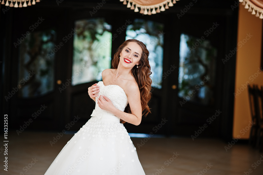Naklejka premium Portrait of beautiful cheerful young bride at wedding hall near