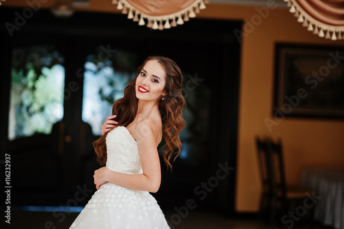 Portrait of beautiful cheerful young bride at wedding hall near