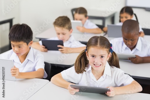 School kids using digital tablet in classroom