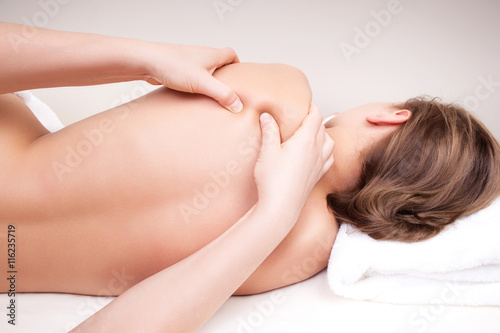 Deep tissue massage on a woman's shoulder blade