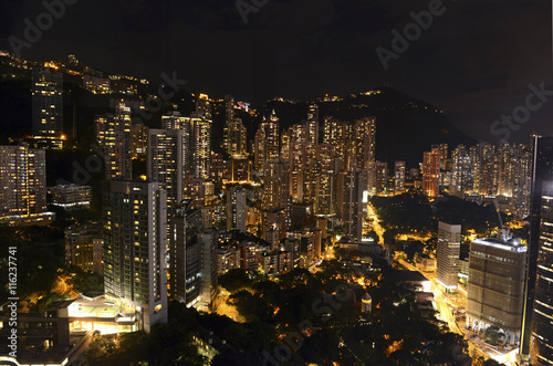 Crowded Hong Kong skyline scene at night with tightly packed skyscrapers and apartment buildings