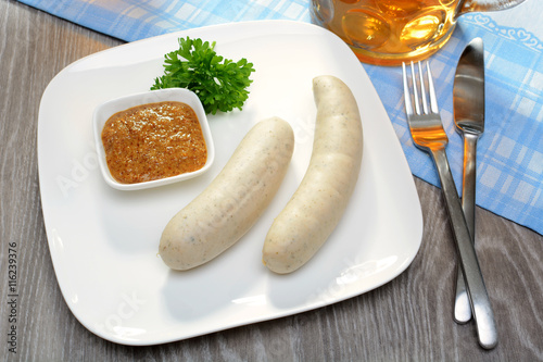 Teller mit Weißwurst, dazu Senf, Petersilie und Maß Bier im Biergarten als Mahlzeit  photo