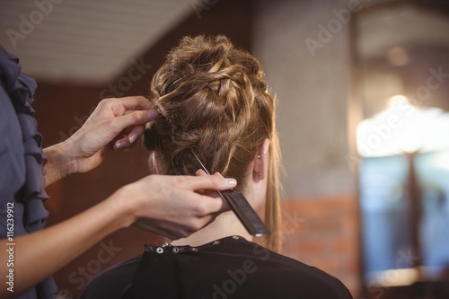 Female hairdresser styling customers hair