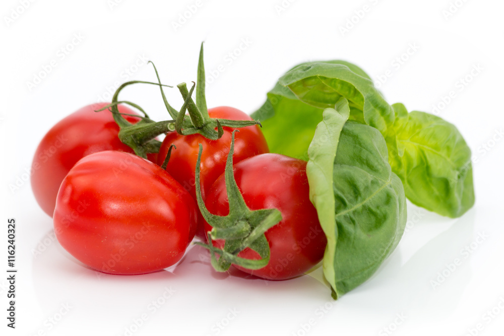Tomaten mit grünem Basilikum freigestellt auf weißem Hintergrund Tomaten mit grünem Basilikum freigestellt auf weißem Hintergrund