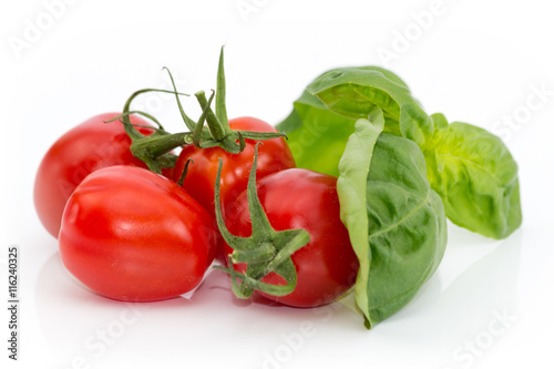 Tomaten mit grünem Basilikum freigestellt auf weißem Hintergrund