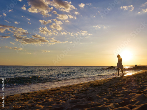 Woman walking the beach in sunset