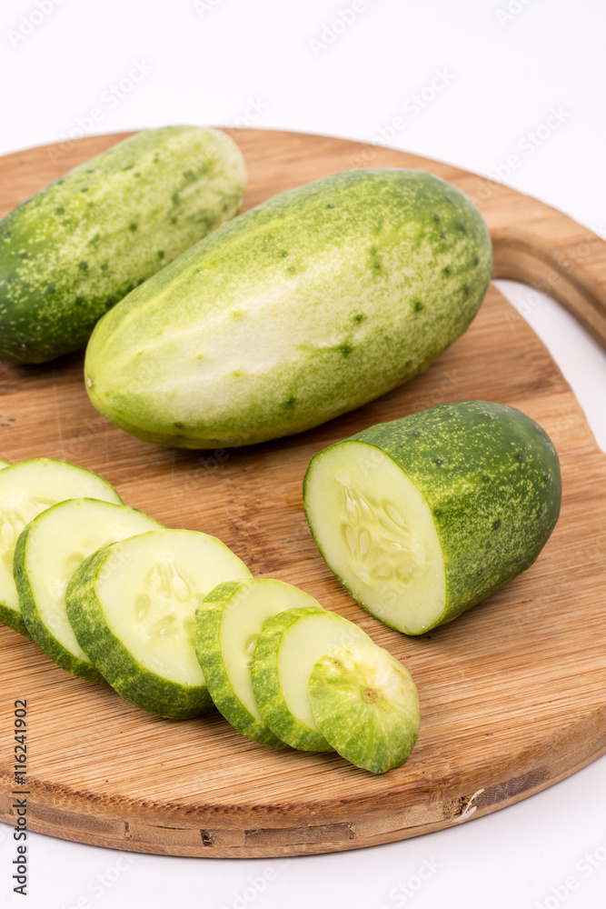 Sliced fresh cucumbers on the round cutting board Sliced fresh cucumbers on the round cutting board