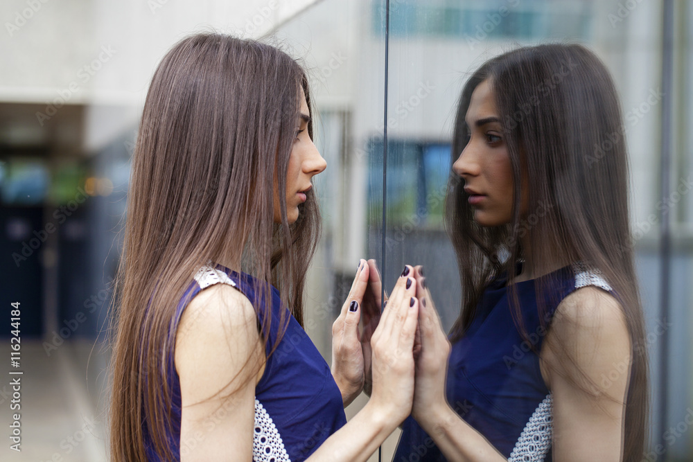 Stylish lady in blue dress posing near mirrored wall Stylish lady in blue dress posing near mirrored wall