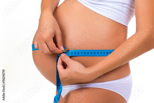Pregnancy. Health of pregnant women. Measuring size tummy with meter tape