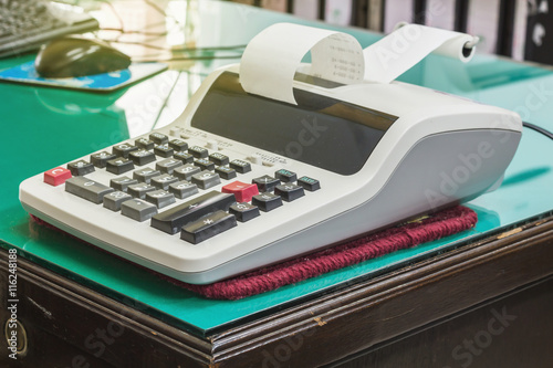 desktop calculator with calculating strip. symbol for costs,
