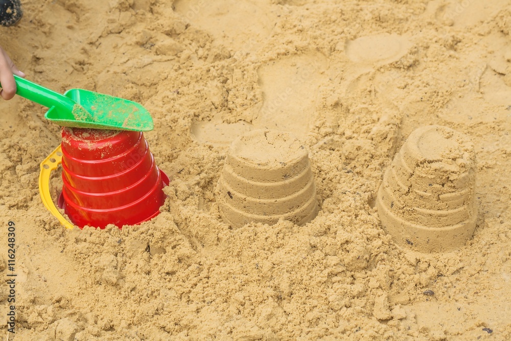 Little girl playing on the beach . Plastic children toys for playing in sandpit or on a beach Little girl playing on the beach . Plastic children toys for playing in sandpit or on a beach