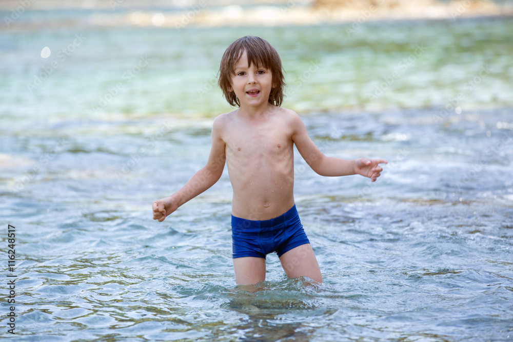 Sweet portrait of little boy on the beach, playing in the water Sweet portrait of little boy on the beach, playing in the water