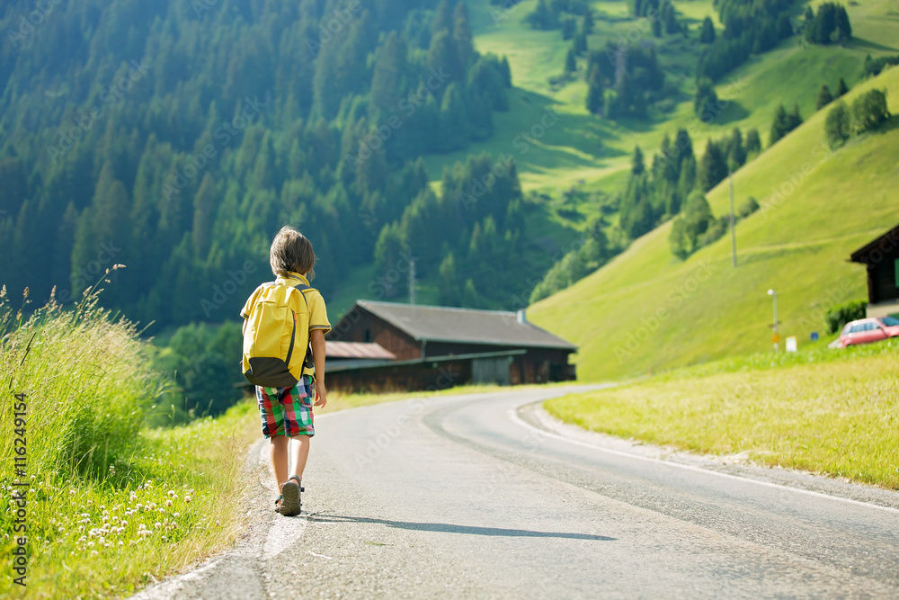 Fototapeta premium Cute little child with backpacks travel on the road to scenic mo