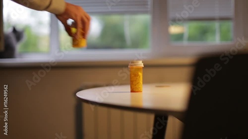 Man takes a bottle of pills on the table
