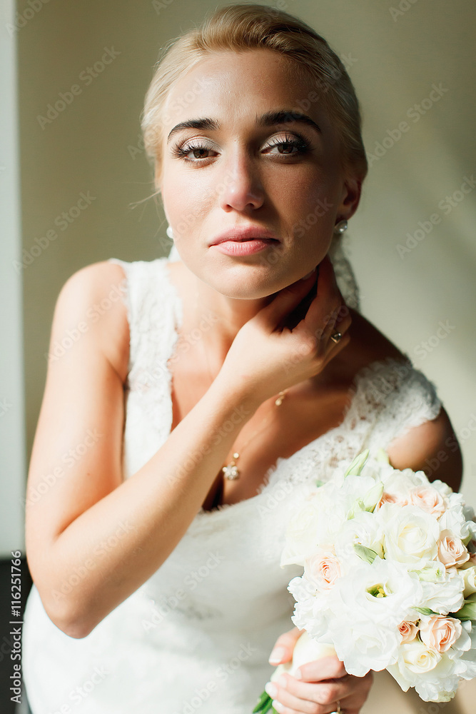 Blond bride looks gorgeous standing in the lights of midday sun Blond bride looks gorgeous standing in the lights of midday sun