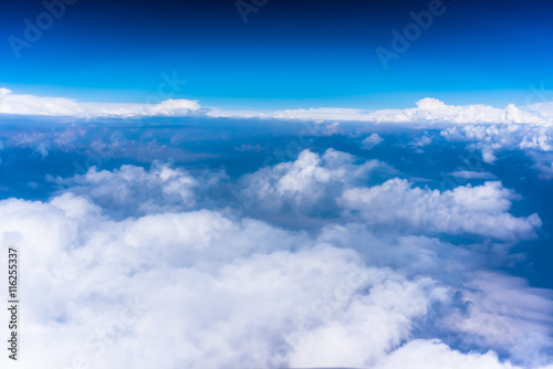 Clouds with blue sky high above the ground photo from airplane