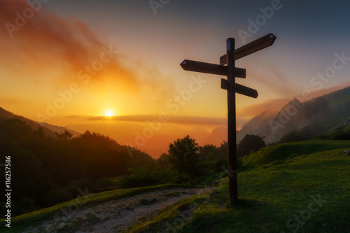 signpost in the mountain at sunset photo