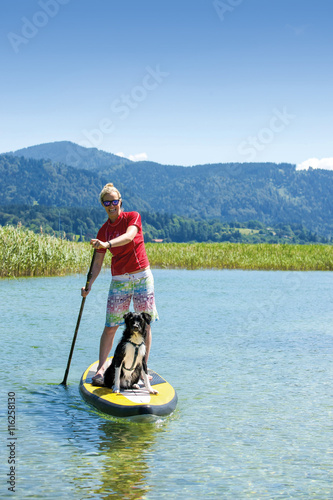 Junge Frau mit Hund auf SUP beim Stand-Up-Paddeln © grafikplusfoto