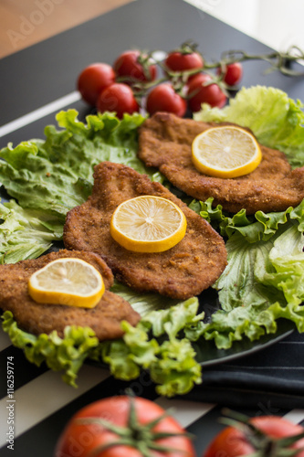 Schnitzel serve with greens and lemon