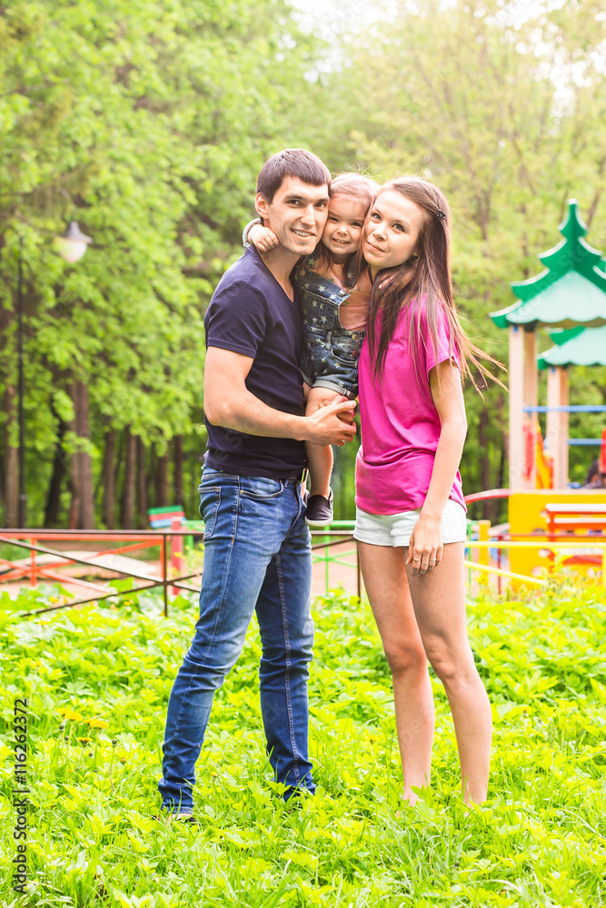 Fototapeta premium Happy mother, father and daughter in the park