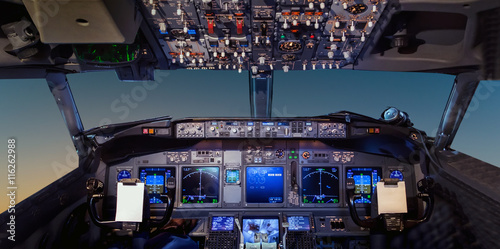 Obraz na płótnie Interior of the cockpit Airplane flying above tropical sunset