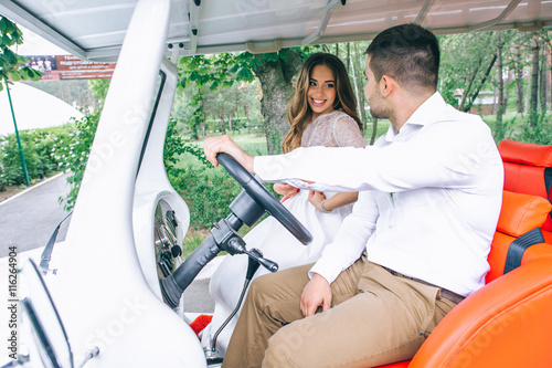 Bride and groom driving a golf cart