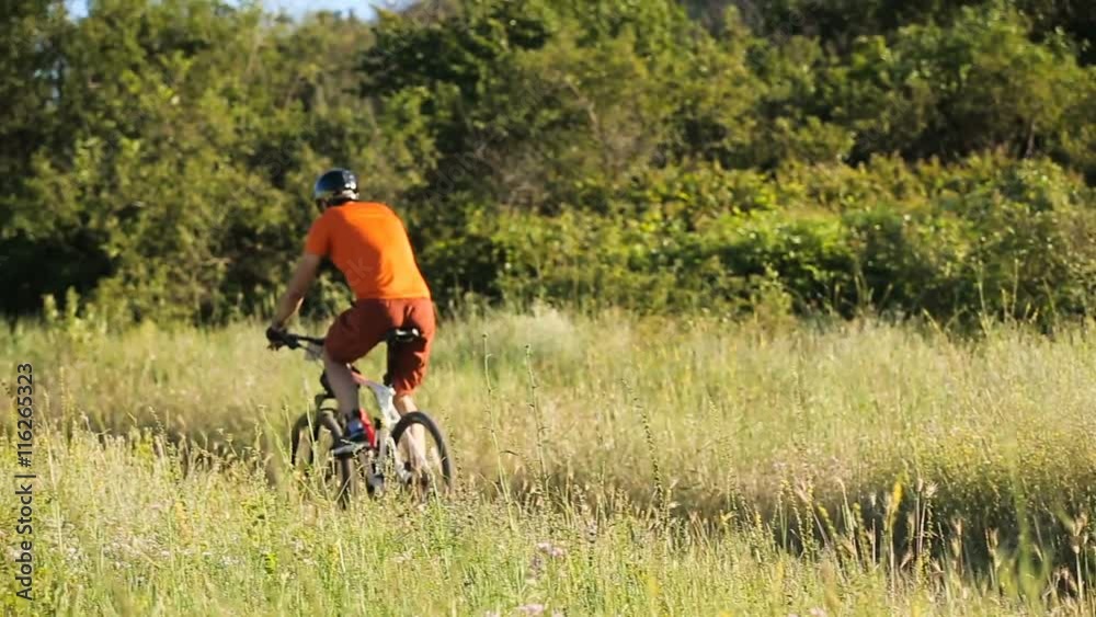 Man on a downhill mountain bike rides down a dirt track in beautiful landscape.Mountain biker fast downhill sport race ride.Cyclist on pathway in mountain forest.Mountain bike. Cyclist rides a bicycle Man on a downhill mountain bike rides down a dirt track in beautiful landscape.Mountain biker fast downhill sport race ride.Cyclist on pathway in mountain forest.Mountain bike. Cyclist rides a bicycle