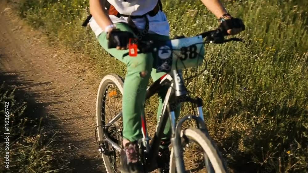 Girl on a downhill mountain bike rides down a dirt track in beautiful landscape.Mountain biker fast downhill sport race ride.Cyclist on pathway in mountain forest.Mountain bike. Cyclist rides a Girl on a downhill mountain bike rides down a dirt track in beautiful landscape.Mountain biker fast downhill sport race ride.Cyclist on pathway in mountain forest.Mountain bike. Cyclist rides a