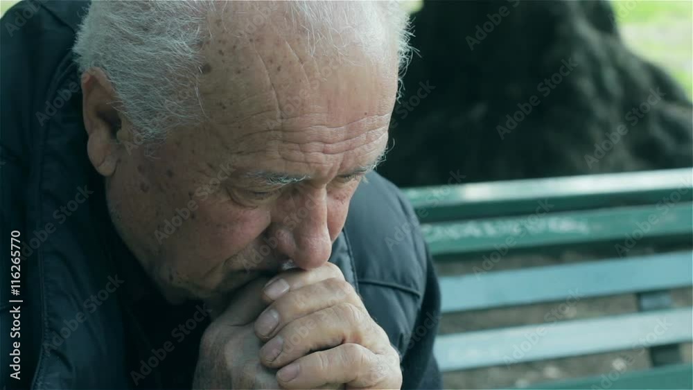 sad old man sitting on the bench 
