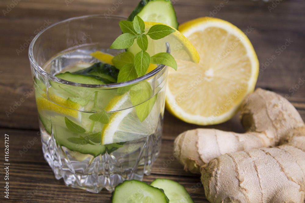 glasses of water with fruit, ginger, cucumber and a sprig of Basil glasses of water with fruit, ginger, cucumber and a sprig of Basil