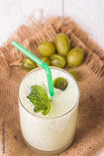 Smoothie in a glass and fresh gooseberries