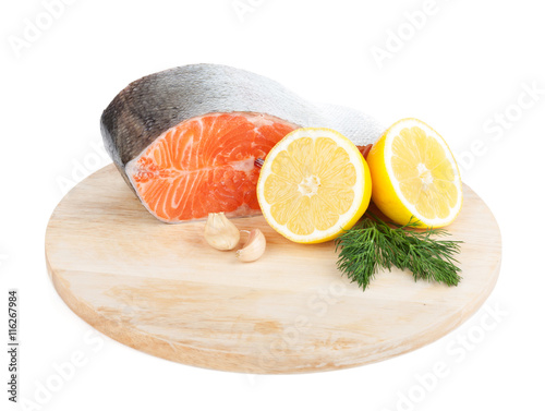 Salmon on cutting board with lemons and herbs