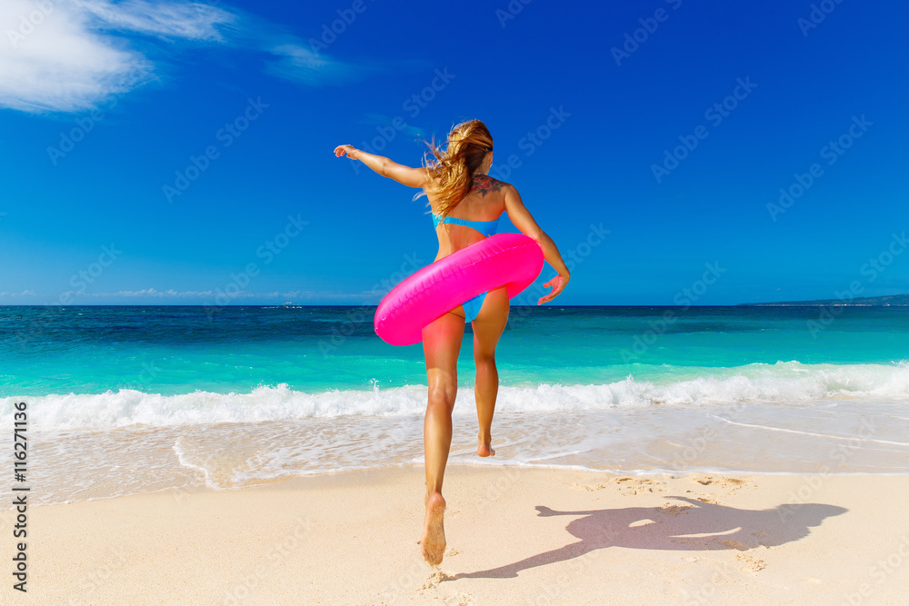 Young beautiful girl in blue bikini having fun on a tropical bea Young beautiful girl in blue bikini having fun on a tropical bea