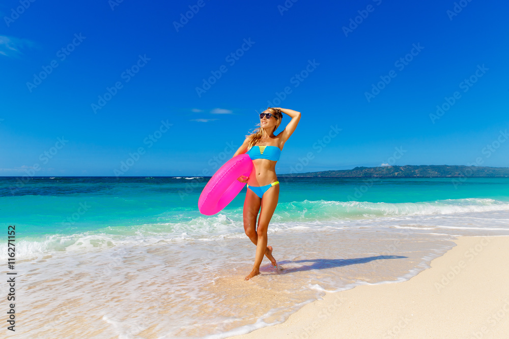 Young beautiful girl in blue bikini having fun on a tropical bea