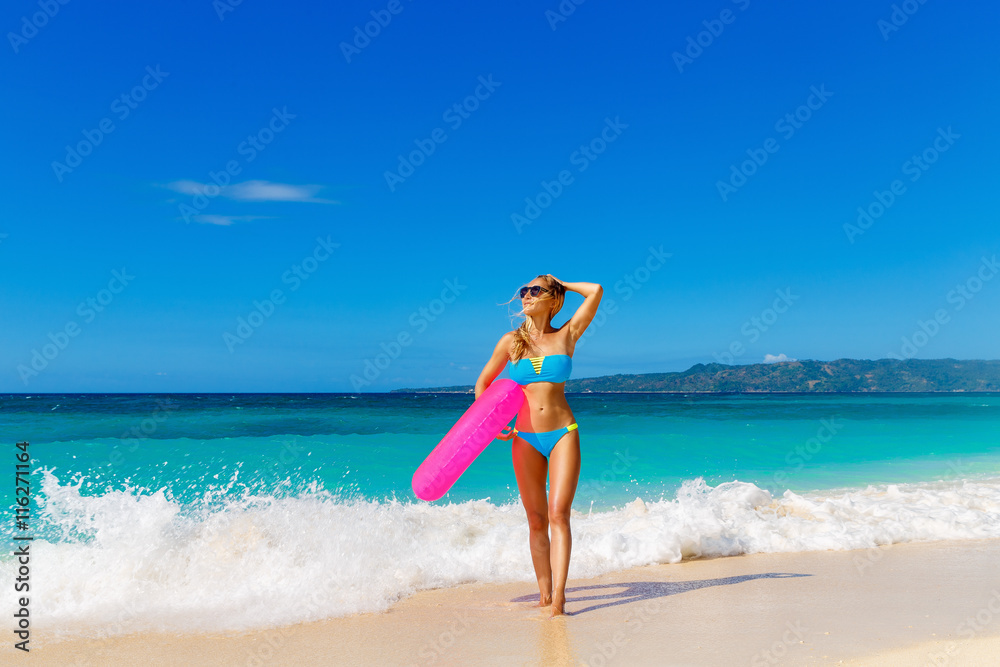 Young beautiful girl in blue bikini having fun on a tropical bea Young beautiful girl in blue bikini having fun on a tropical bea
