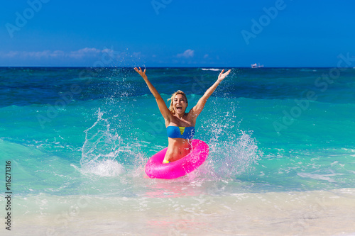 Young beautiful girl in bikini swims in a tropical sea on a rubb