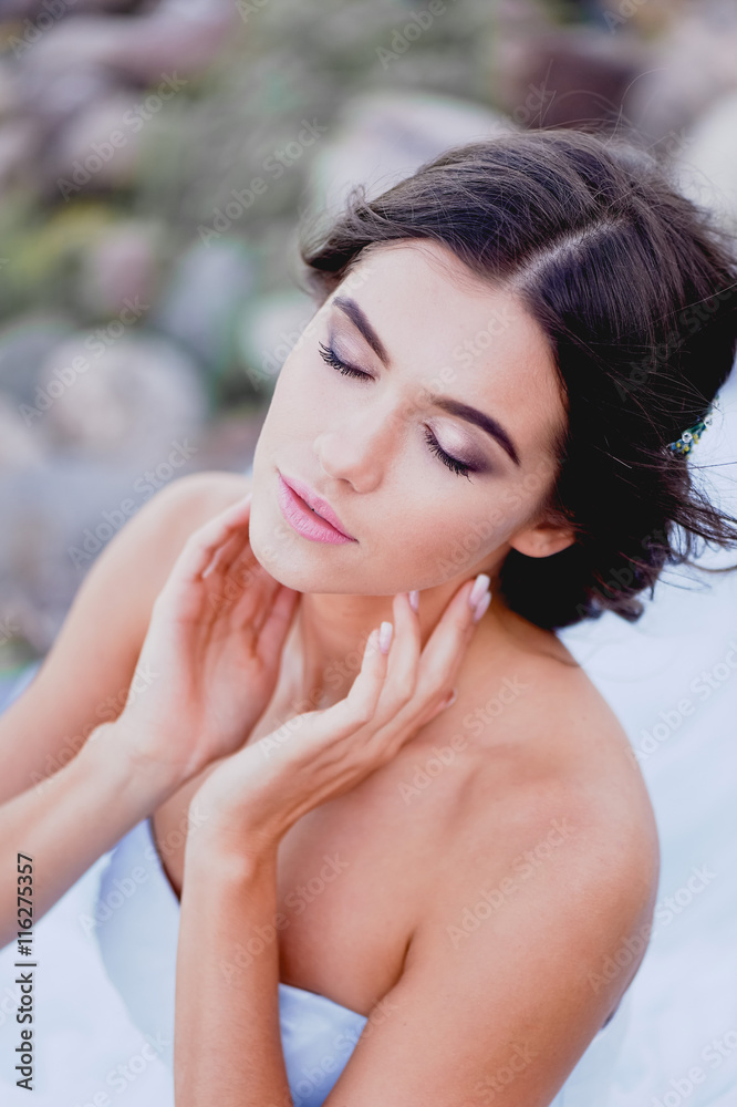 Fototapeta premium Gorgeous brunette with hair parted touches the face, covering his eyes