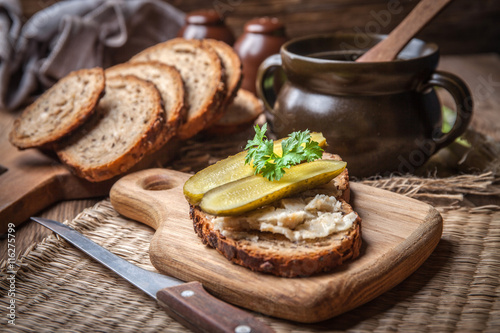 A slice of country bread with homemade lard and cucumber. photo