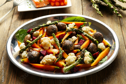 Vegetable salad with mushrooms and baby carrot on wooden background