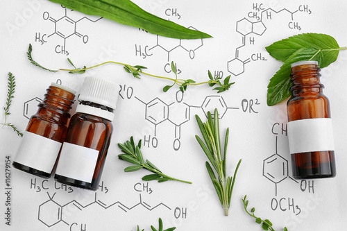 Tableau sur toile Dropper bottles and herbs on chemical formulas background